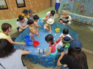 ビニールプールで子どもたちが水遊びをしている写真