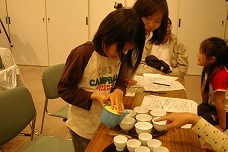 お茶の入れ方教室で、湯呑みに均等の量と濃度でお茶を注ぐ子どもの写真